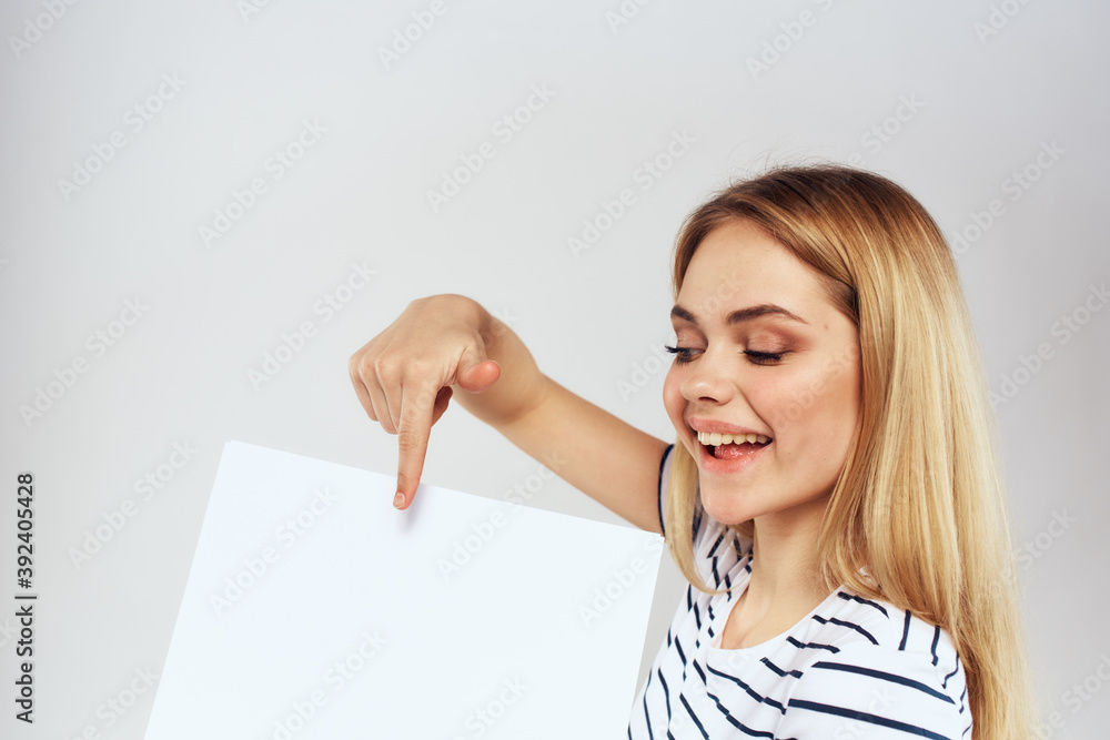 woman holding a sheet of paper in her hands lifestyle striped t-shirt cropped view Copy Space woman holding a sheet of paper in her hands lifestyle striped t-shirt cropped view Copy Space