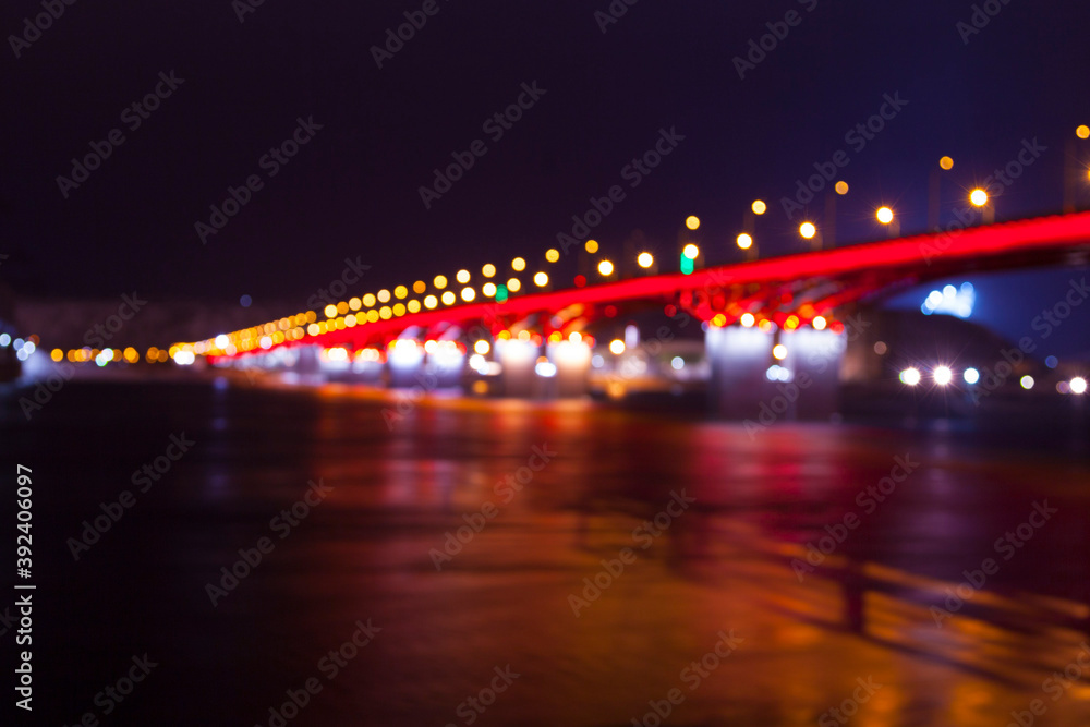 background of the defocused lights of the night city, a bridge across the river