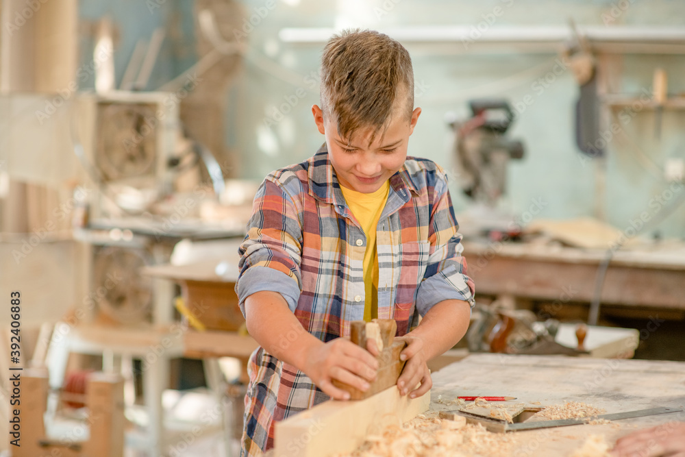 Young boy planed wood in a workshop Young boy planed wood in a workshop