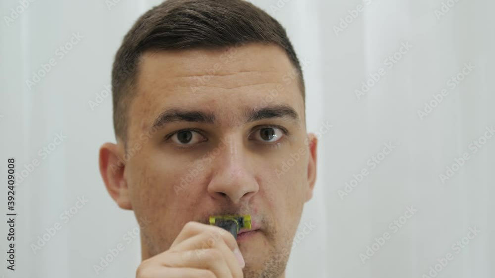 Close up handsome man is shaving beard and moustache using electric razor. Close up handsome man is shaving beard and moustache using electric razor.