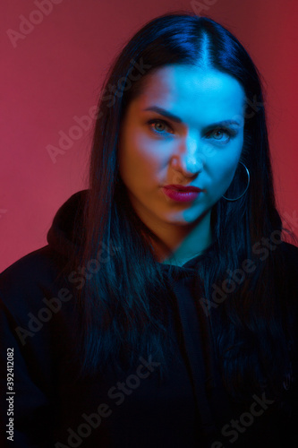 Portrait of a young woman in the Studio in colored red and blue light