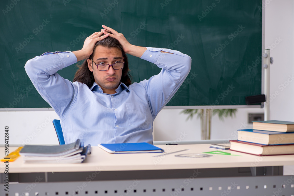 Young male teacher in front of green board Young male teacher in front of green board