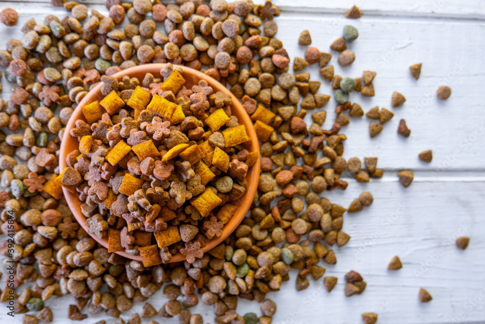 Top view of natural pet food in a clay bowl on white table Top view of natural pet food in a clay bowl on white table