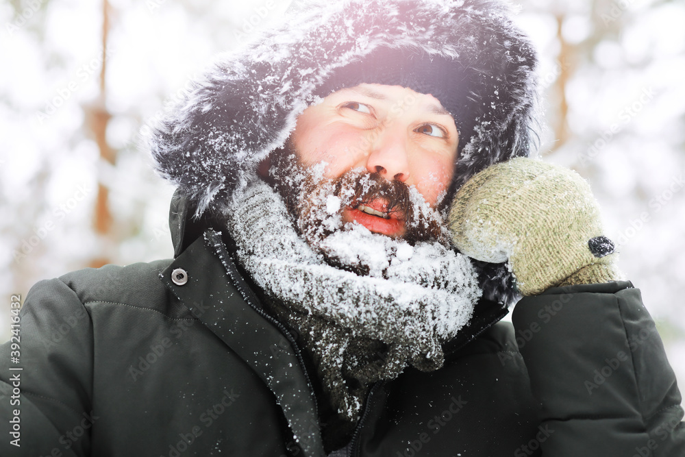 Outdoor portrait of handsome man in coat and scurf. Bearded man in the winter woods. Outdoor portrait of handsome man in coat and scurf. Bearded man in the winter woods.