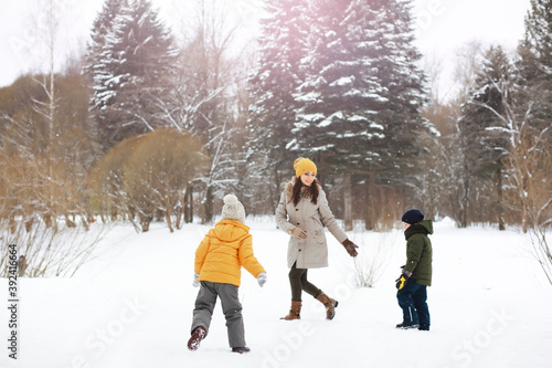 Happy family playing and laughing in winter outdoors in the snow. City park winter day.