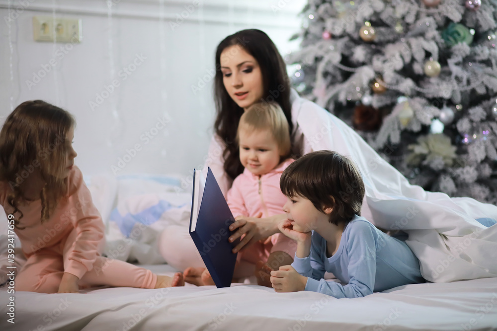 A family with children having fun on the bed under the covers during the Christmas holidays. A family with children having fun on the bed under the covers during the Christmas holidays.