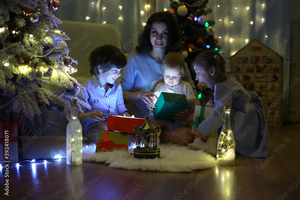 New Years Eve. The house is decorated for the holiday. Smartly dressed Christmas tree with a garland and a family with gifts and a surprise. New Years Eve. The house is decorated for the holiday. Smartly dressed Christmas tree with a garland and a family with gifts and a surprise.