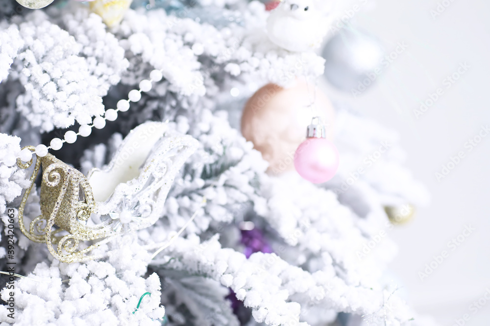 Christmas holiday background. Silver and color bauble hanging from a decorated on tree with bokeh and snow, copy space. Christmas holiday background. Silver and color bauble hanging from a decorated on tree with bokeh and snow, copy space.