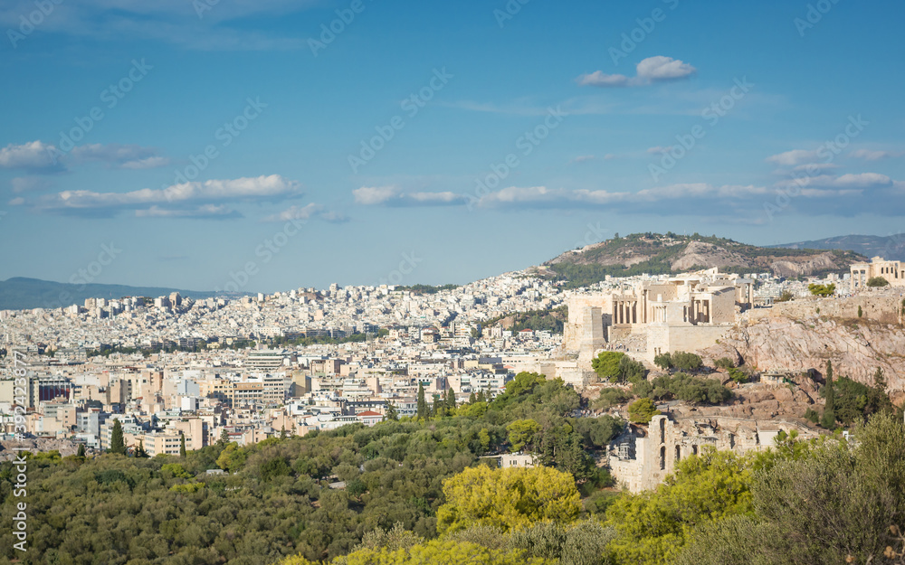 View of the city in Athens with the Propylaea in the distance against the blue sky