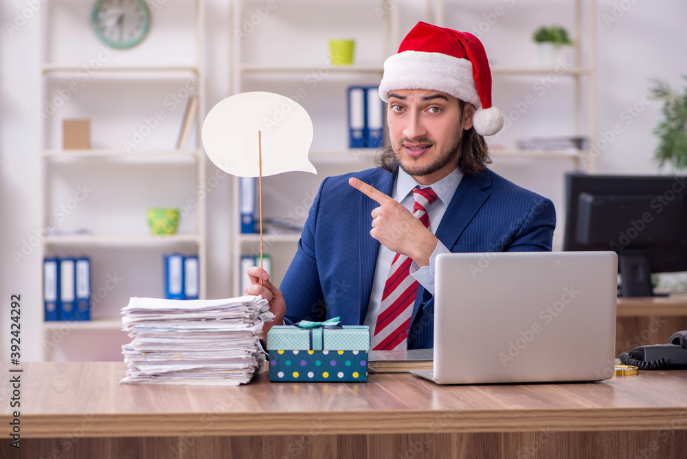 Young male employee working in the office at Christmas Eve Young male employee working in the office at Christmas Eve