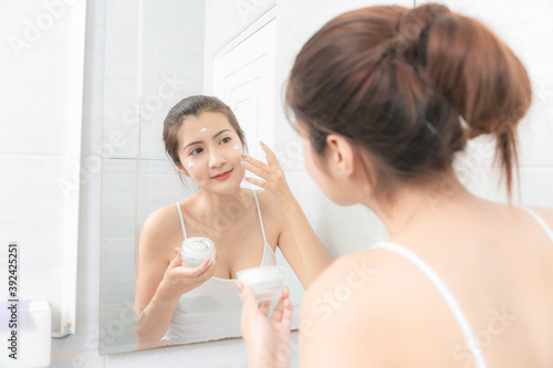 Close up asian  beautiful woman applying face cream.