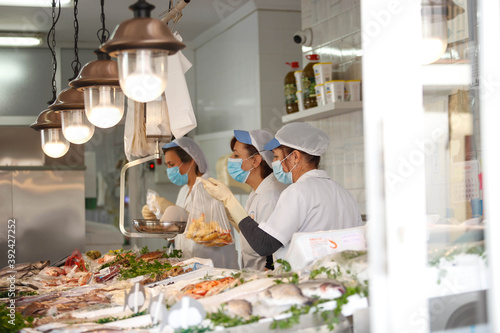 Tableau sur toile Working portrait of a fishmonger with workers