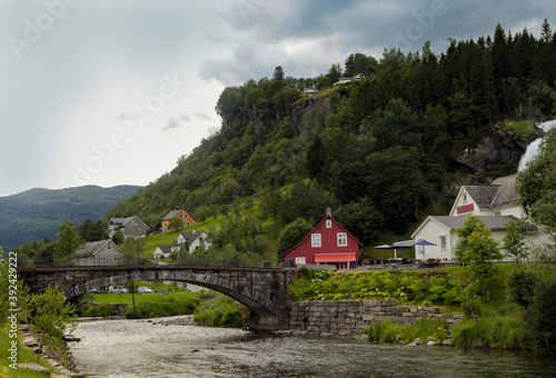 Typical Norwegian house near one of the most popular waterfalls in Norway - Steinsdalsfossen, on the Fosselva river in western Norway