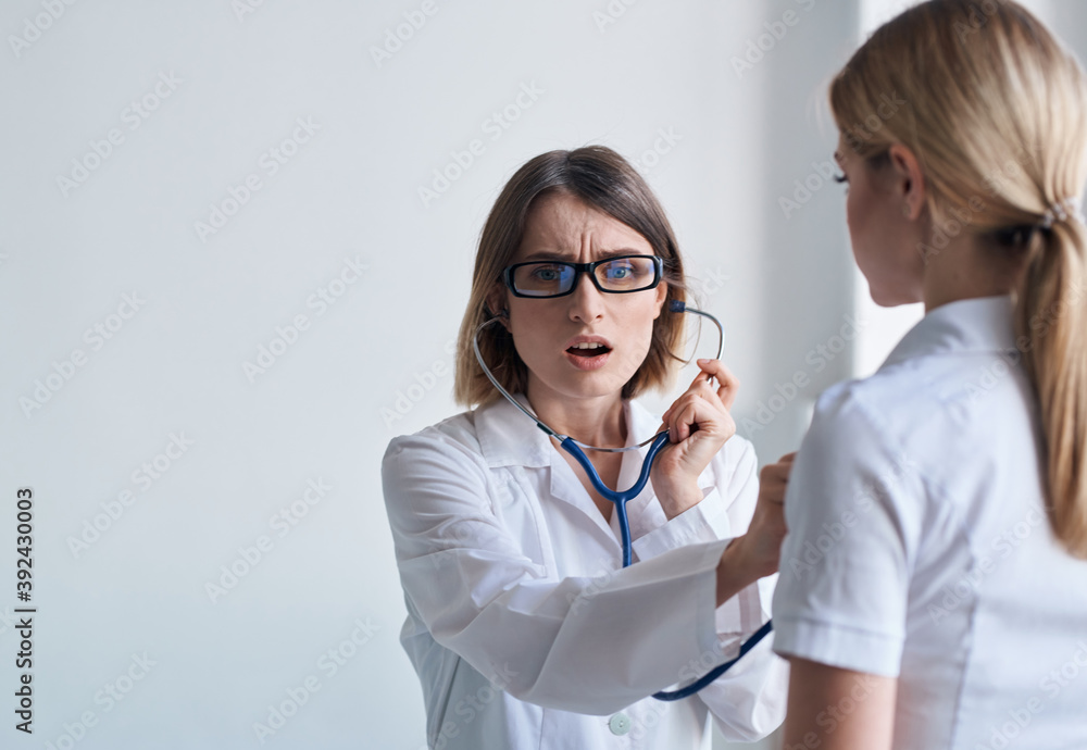 Woman doctor with stethoscope and glasses examines the patient health model Woman doctor with stethoscope and glasses examines the patient health model