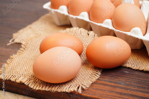 Hot fried eggs and fresh eggs on the wooden table