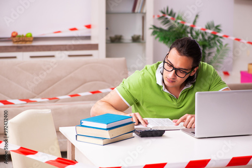 Young male student studying at home in self-isolation concept