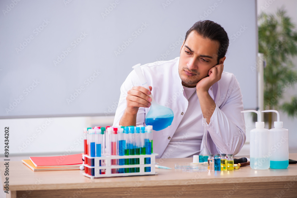 Young male chemistry teacher in the classroom Young male chemistry teacher in the classroom