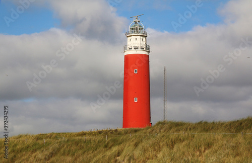  West Frisian Islands in the Netherlands. Red lighthouse on the sandy shore of Texel Island.