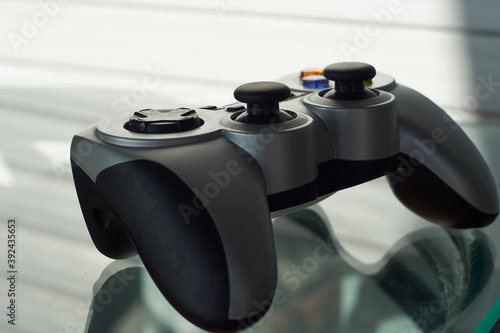 Video game controller on a glass table. Wireless gamepad or joystick.