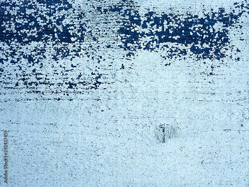 the board is painted with different colors of white and blue, the texture of the wood and old paint is falling off, the background