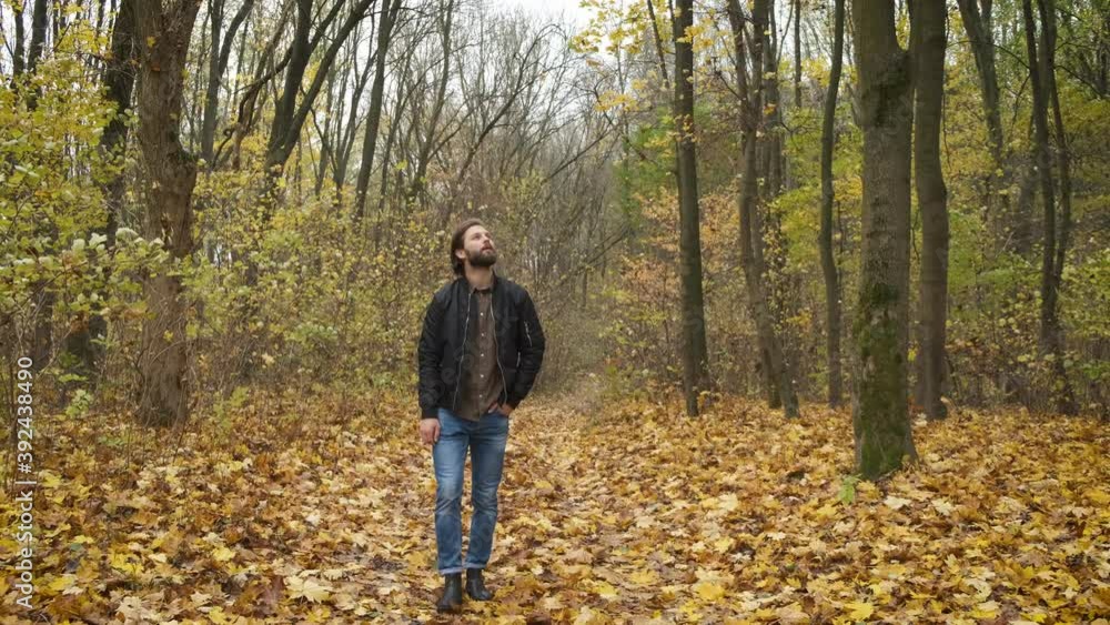 Sad bearded man walks in the park. Depression. Hard days and self-isolation during the epidemic Sad bearded man walks in the park. Depression. Hard days and self-isolation during the epidemic
