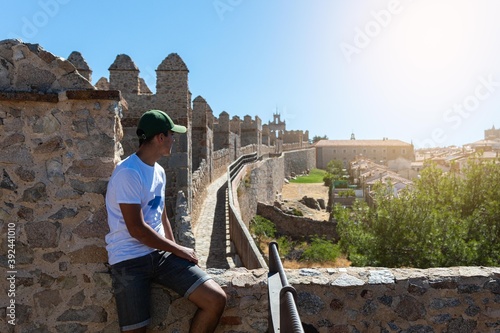 Selective focus of a boy on top of the wall of the fortress of Avila in Spain photo
