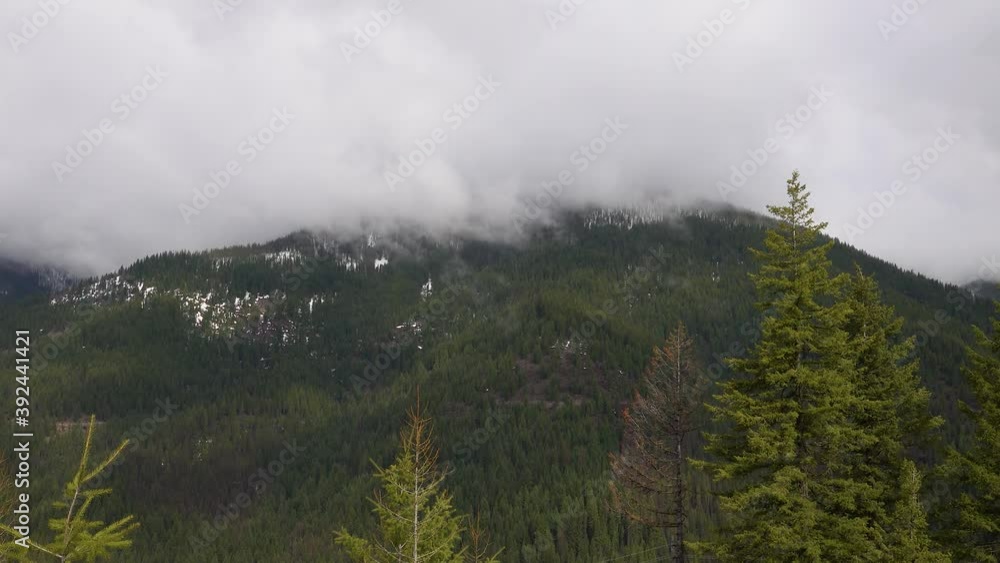 Mountains in the snow, overgrown with wood. Thick clouds over the mountains. Montana, USA Mountains in the snow, overgrown with wood. Thick clouds over the mountains. Montana, USA