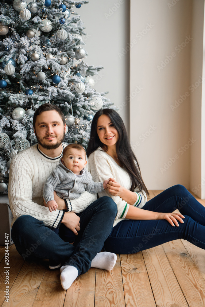 Young family near festive Christmas tree Young family near festive Christmas tree