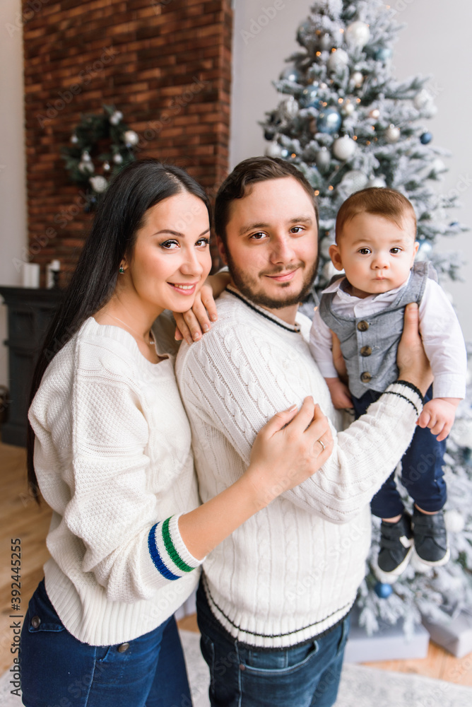 Young family near festive Christmas tree Young family near festive Christmas tree