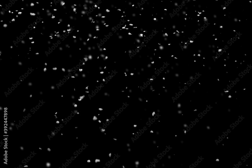 Falling snow on a black isolated background. Snow background. Flying snowflakes.
