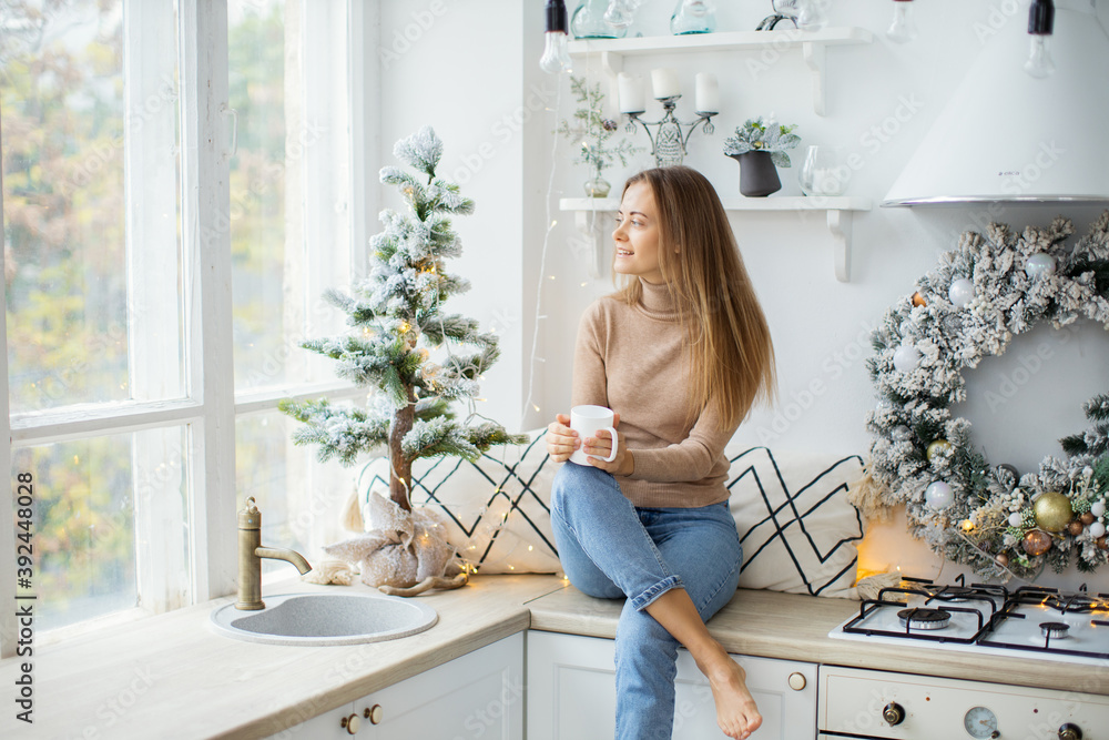 Young attractive woman at home near the Christmas tree.
