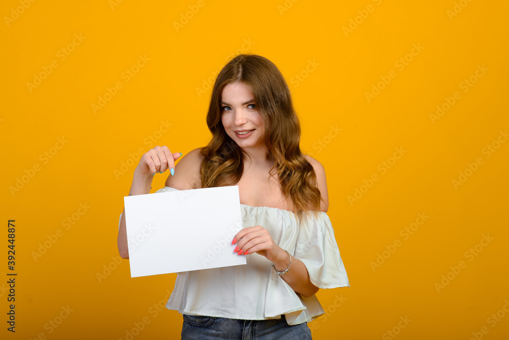 Dark-haired young woman with a smile and big suprised eyes posing on yellow background. Dark-haired young woman with a smile and big suprised eyes posing on yellow background.