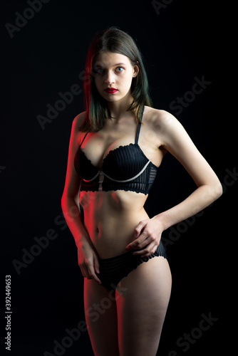 Cute brunette female model posing  wearing black underwear in dark studio
