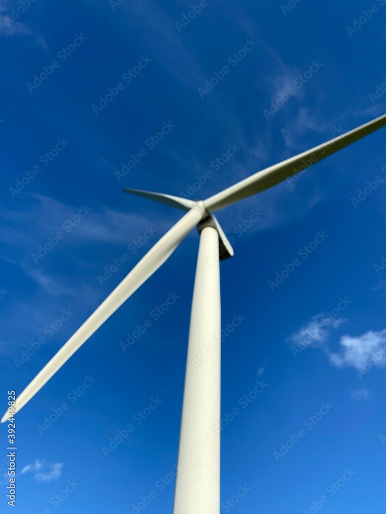 Wind farm turbines that produce electricity energy. Windmill Wind power technology productions Wind turbines standing in green field - stock footage Wind farm turbines that produce electricity energy. Windmill Wind power technology productions Wind turbines standing in green field - stock footage