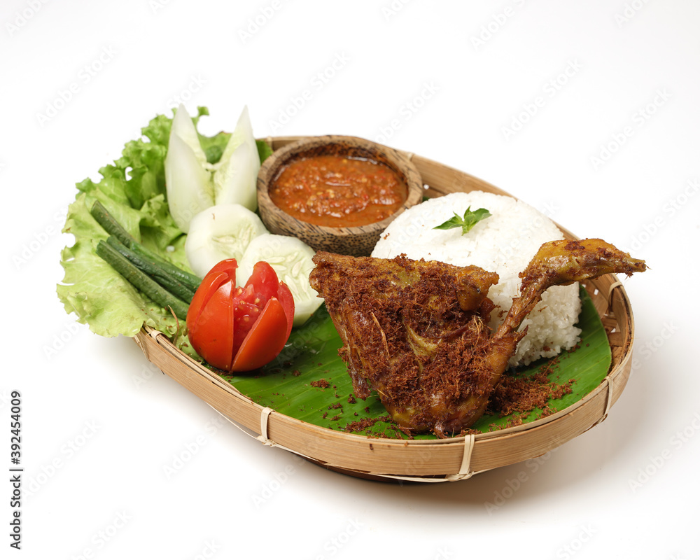 Fried chicken with ripe golden skin laid out on a wooden sheet on a white background, plus white rice, chili sauce and various vegetables, view from above. commonly used for menus and picture packs. Fried chicken with ripe golden skin laid out on a wooden sheet on a white background, plus white rice, chili sauce and various vegetables, view from above. commonly used for menus and picture packs.