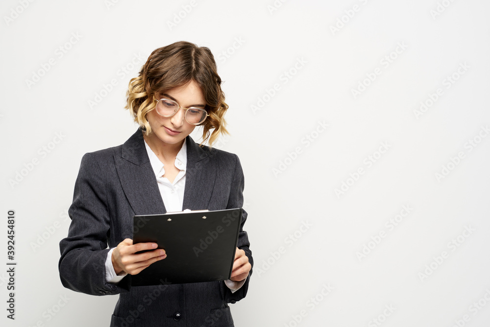 business woman in a suit with documents in hands light background curly hair hairstyle business woman in a suit with documents in hands light background curly hair hairstyle