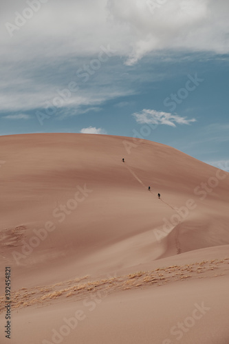 Close up of hikers hiking Star Dune  the tallest sand dune in Great Sand Dunes National Park in Colorado  USA.