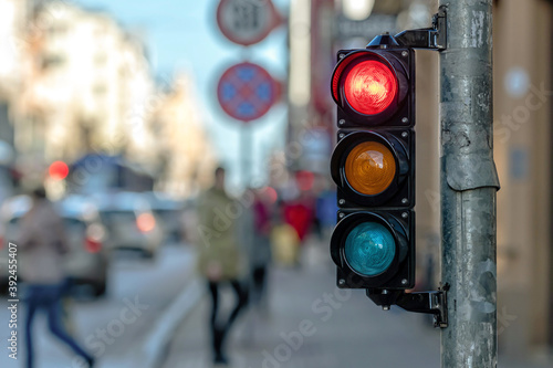 traffic semaphore with red light against the backdro of the city traffic