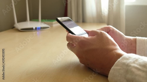 Men hand using smartphone device to connect to wifi network from internet router. Broadband high speed internet network technology for access to many application and services online.