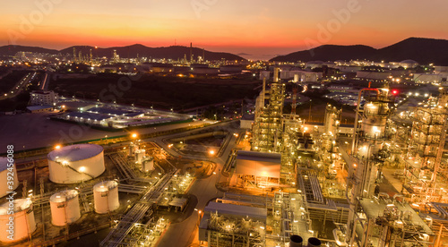 Aerial view of pipe and chemical oil refinery plant, power plant and metal pipe on sunset sky background.