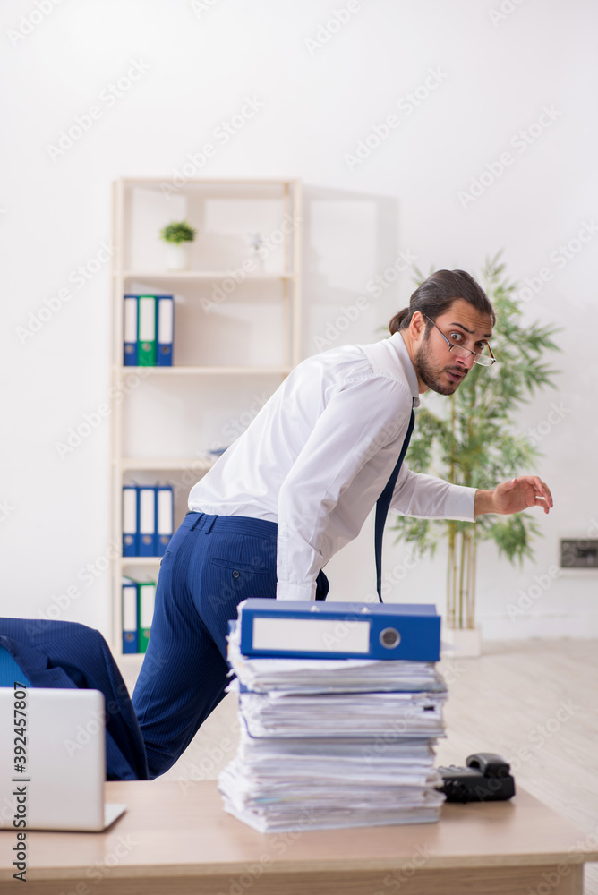 Young businessman unhappy with excessive work in the office