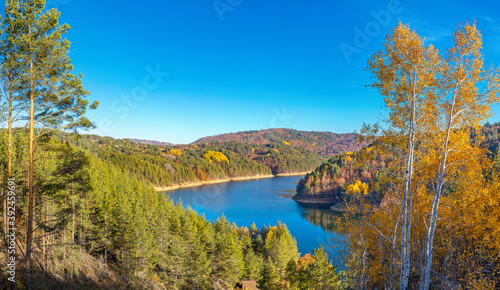 Colorful autumn landscape with mountain lake in pine forest. Berovo lake, North Macedonia.