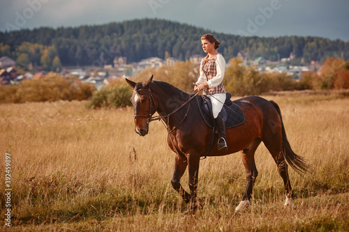 Young woman horseriding in sunset on the fields. Close up