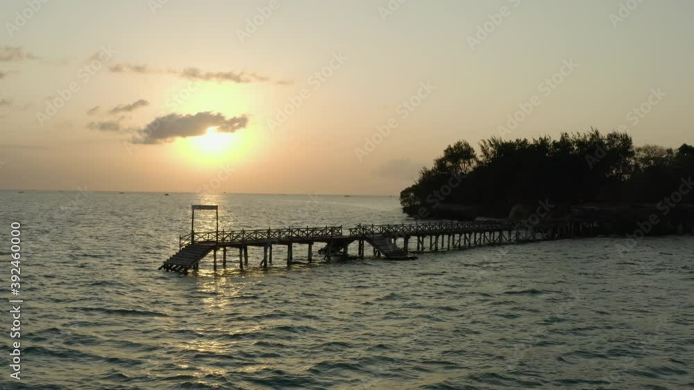 Aerial shot Zanzibar Tanzania. Drone video pier near the island with rocks and trees in the Indian Ocean at sunset with beautiful sky and landscape. Aerial shot Zanzibar Tanzania. Drone video pier near the island with rocks and trees in the Indian Ocean at sunset with beautiful sky and landscape.