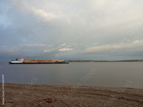 The barge carries the wood on the river