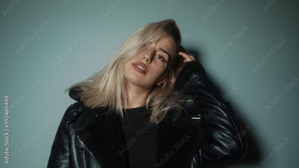 Alluring young sexy and beautiful blonde woman looking at camera giving attractive poses in cyan-color studio background, lifestyle, fashion and photography concept Alluring young sexy and beautiful blonde woman looking at camera giving attractive poses in cyan-color studio background, lifestyle, fashion and photography concept