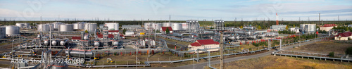 Panorama of Large Oil Industrial Facility, equipment, pipelines, tanks with oil products, utilities.