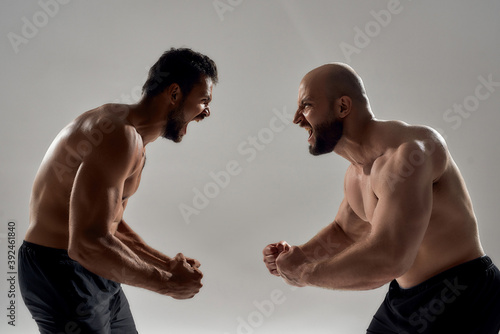 Young brutal caucasian bodybuilders screaming at each other