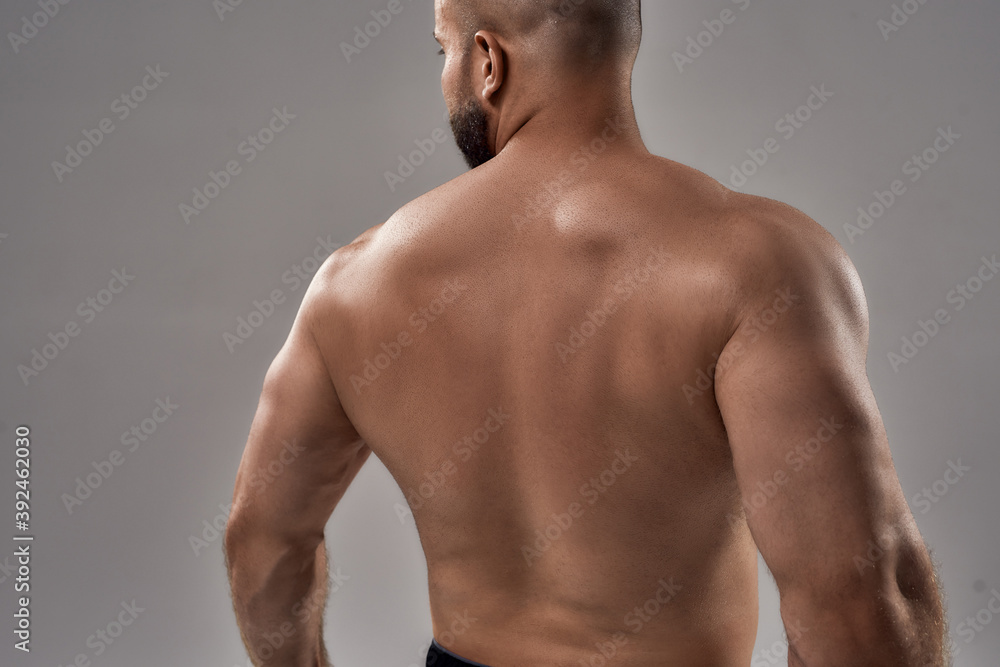 Young caucasian athlete showing muscular back Young caucasian athlete showing muscular back