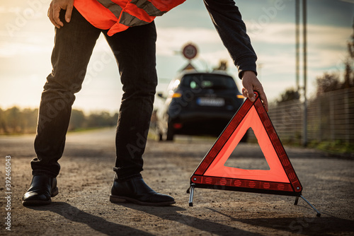 Warndreieck wird aufgestellt und warnt vor Autopanne